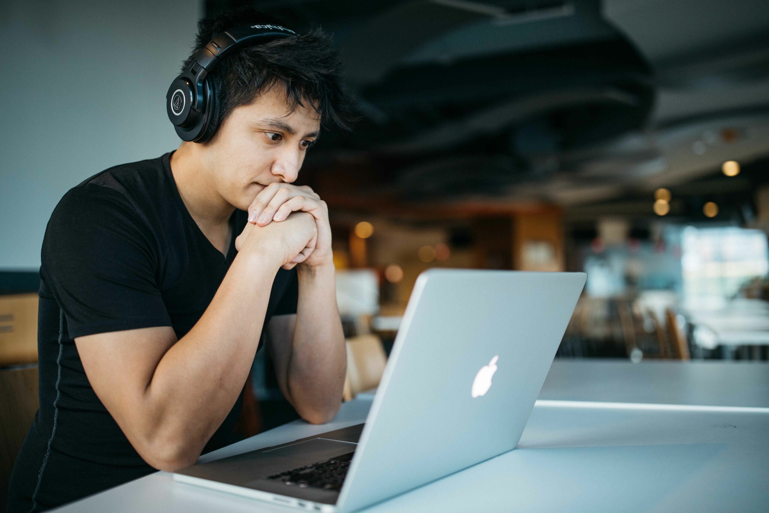 stock image of Asian man with a laptop and headphones